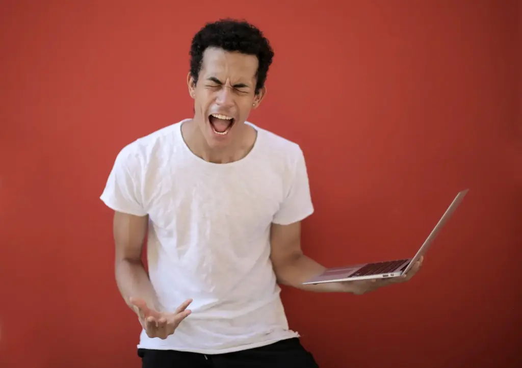Emotionaler Stress bei Mann mit Laptop