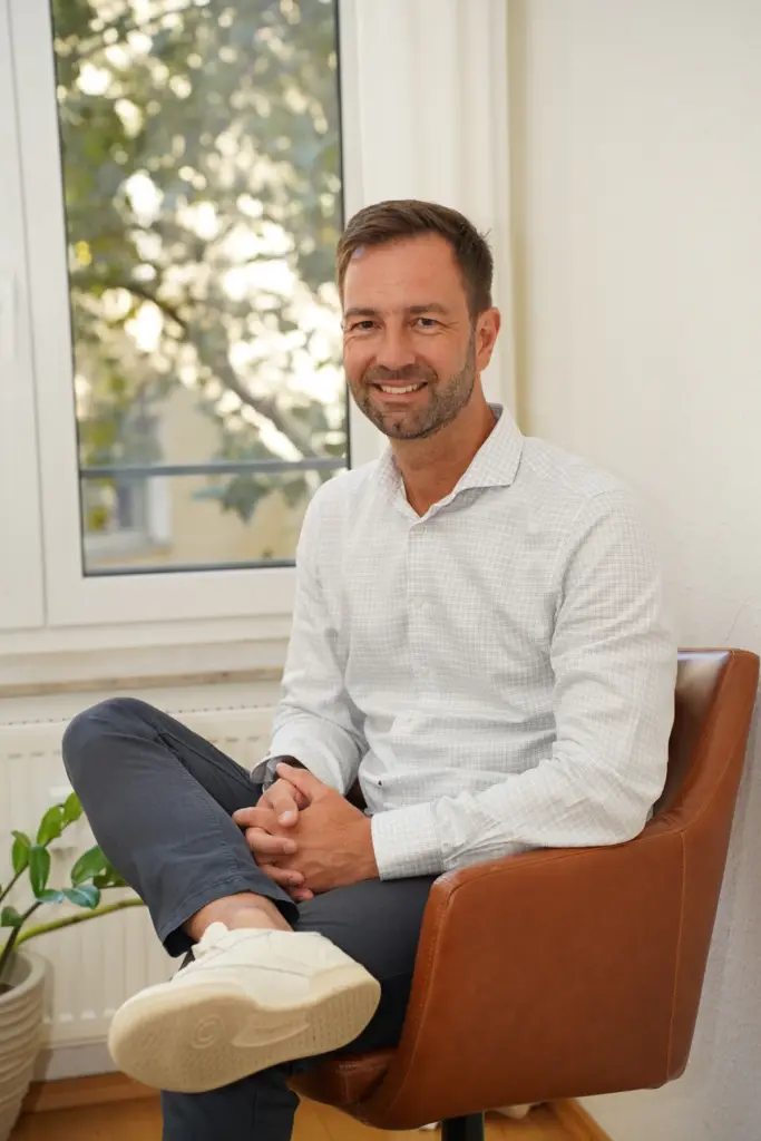 self-leadership-journey-hero-thomas-waaden Thomas Waaden sitzt entspannt in einem Sessel und blickt in die Kamera.